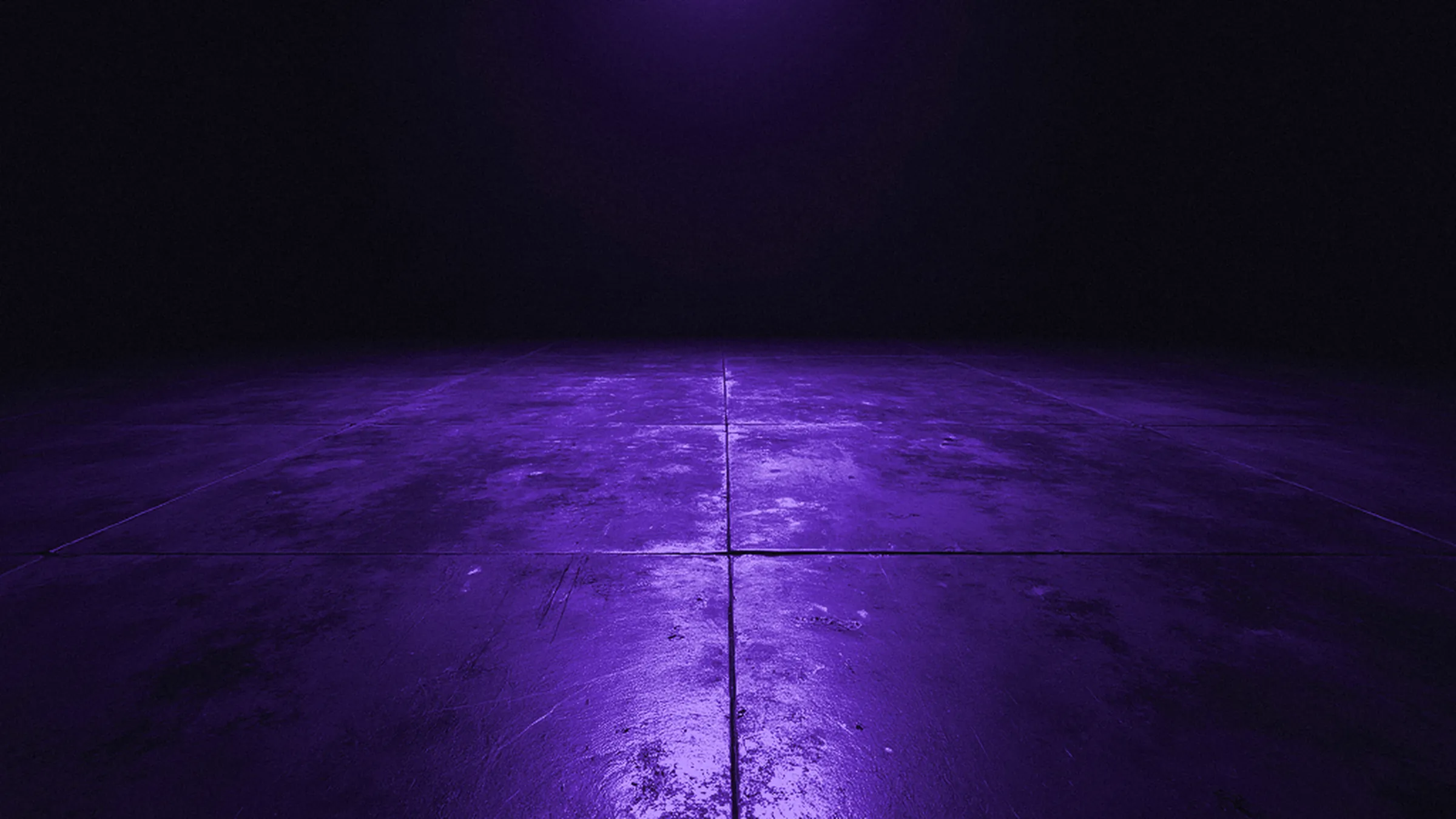 A tiled stage floor under a violet gel